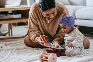 Parent reading a book to their newborn child